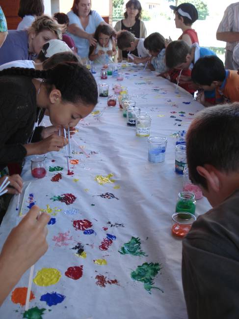 Atelier  la peinture souffle  : 
L'animatrice lit un texte sur la cration. Certains mots du texte abordent un thme et une couleur correspond  ce thme, exemple le bleu pour la mer... A chaque mot, les enfants choisissent une couleur
Une fresque est ainsi ralise petit  petit. Ce n'est pas facile, car il faut aspirer de la peinture dans la paille sans en avaler, et ensuite la souffler avec force ! Mais rassurez vous, cette peinture n'est pas toxique !!!
Mais  la fin cette belle fresque sera expose lors de la clbration.